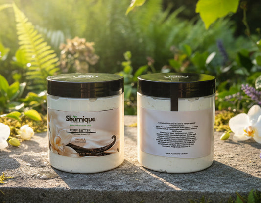 Two jars of Shurnique Vanilla Body Butter sitting on a green wooden fence outdoors with trees in the background.